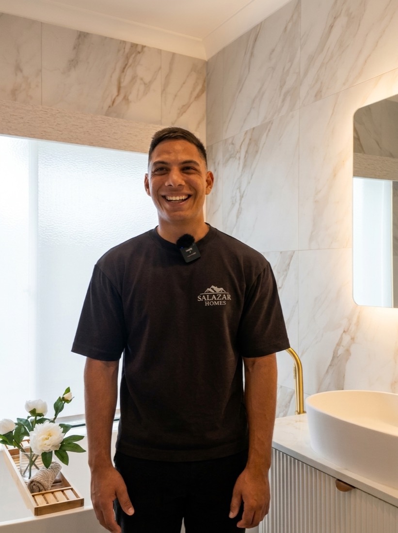 Eleazar from Salazar Homes standing in a completed marble bathroom renovation