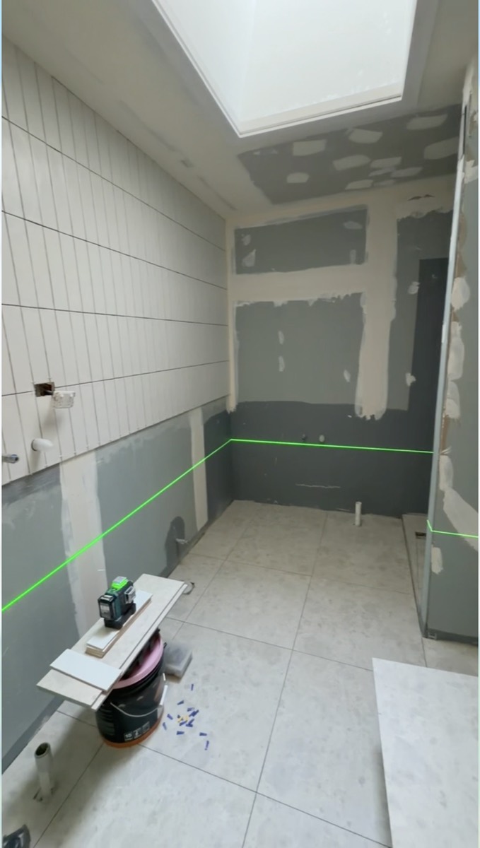 Waterproofing membrane applied to walls and floor, set out with a laser level